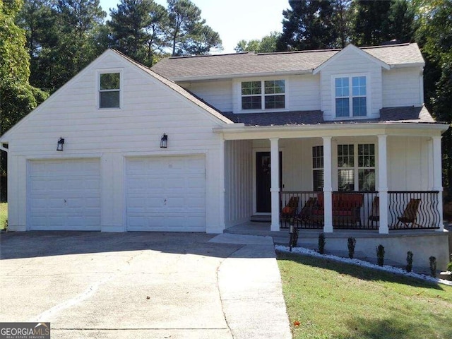 view of front of house featuring covered porch, a garage, and a front yard