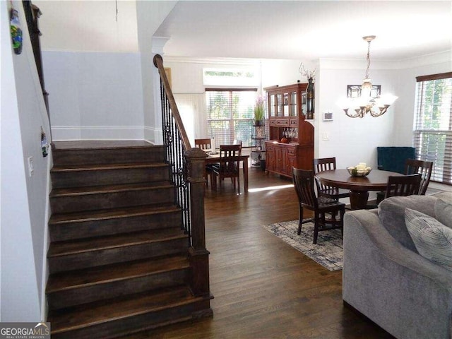 interior space featuring hardwood / wood-style flooring, ornamental molding, and an inviting chandelier