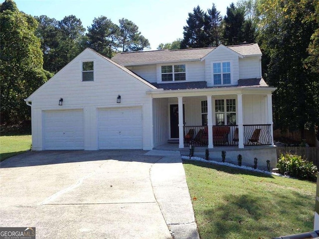 view of front of house featuring a front yard, a garage, and a porch