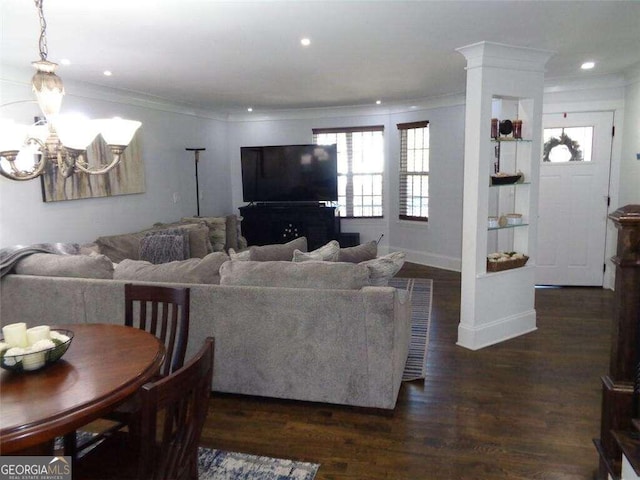 living room featuring crown molding, dark hardwood / wood-style flooring, and a chandelier