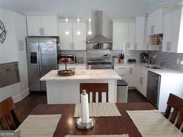 kitchen featuring a kitchen island, wall chimney exhaust hood, sink, white cabinets, and appliances with stainless steel finishes