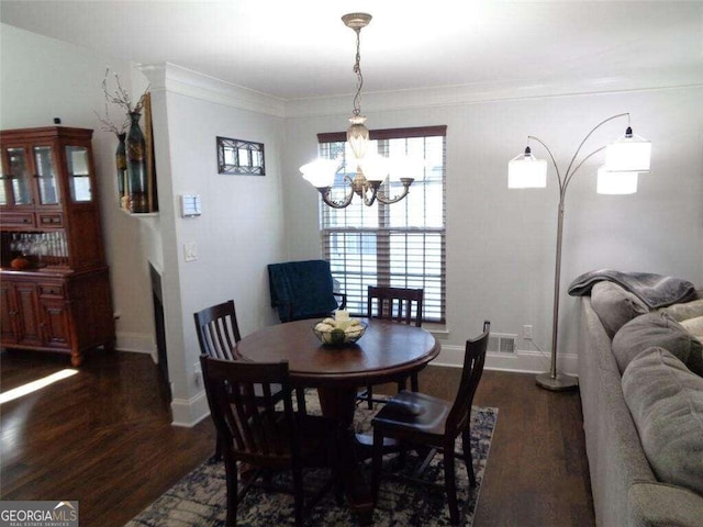 dining room featuring crown molding, a chandelier, dark wood-type flooring, and plenty of natural light