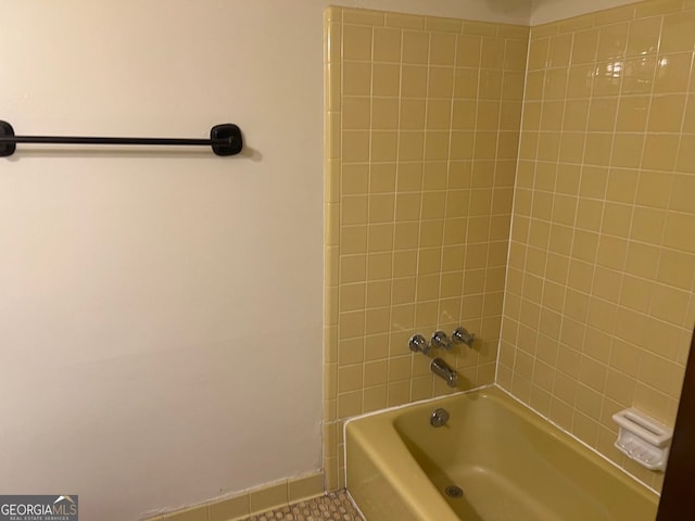 bathroom featuring tiled shower / bath combo and tile patterned flooring