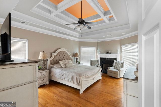 bedroom with light wood-type flooring, multiple windows, and coffered ceiling