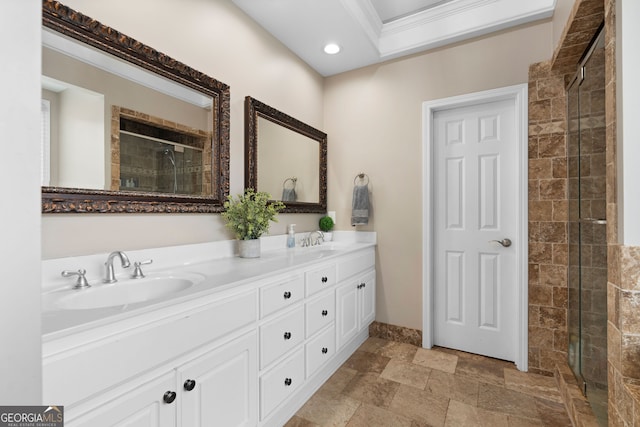 bathroom with vanity, a shower with shower door, and crown molding