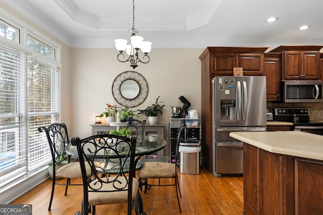 kitchen featuring backsplash, stainless steel appliances, decorative light fixtures, light hardwood / wood-style flooring, and a chandelier