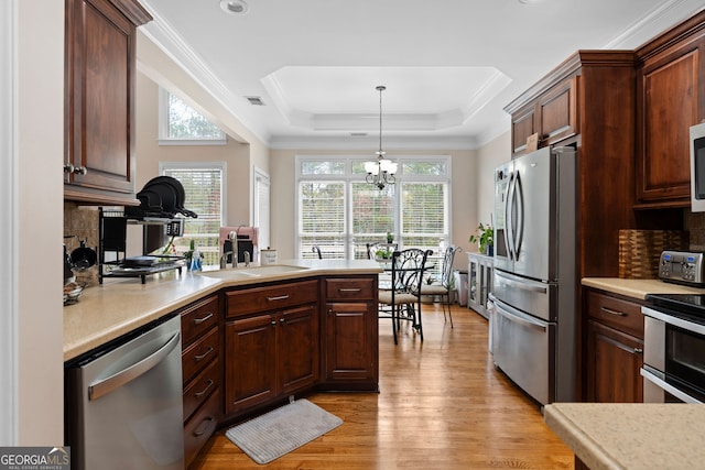 kitchen with sink, stainless steel appliances, a chandelier, decorative light fixtures, and light hardwood / wood-style floors