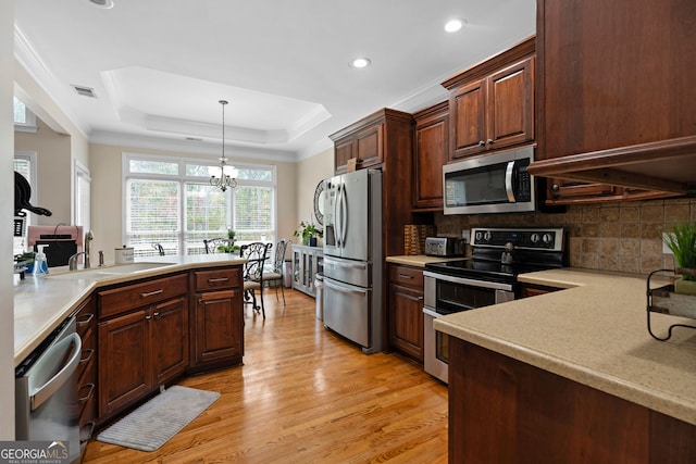 kitchen featuring stainless steel appliances, light hardwood / wood-style flooring, a notable chandelier, backsplash, and decorative light fixtures