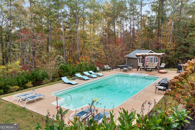 view of swimming pool with an outbuilding and a patio