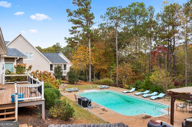 view of pool featuring a patio and a wooden deck