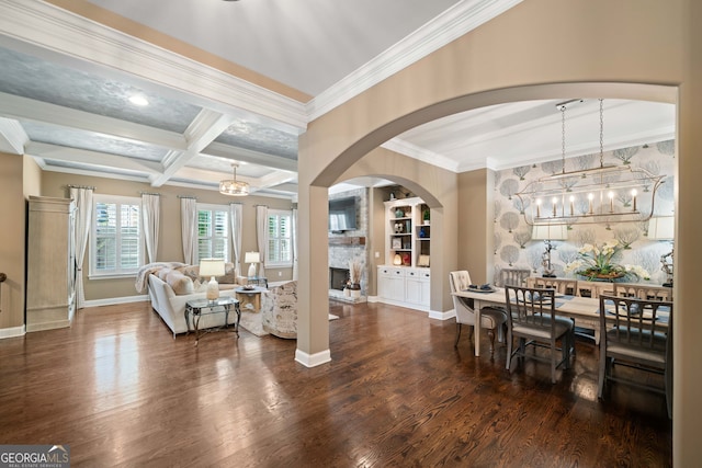 living room with beam ceiling, dark hardwood / wood-style floors, a fireplace, crown molding, and coffered ceiling