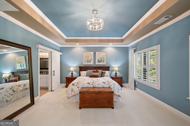 carpeted bedroom featuring an inviting chandelier, ornamental molding, and ensuite bath