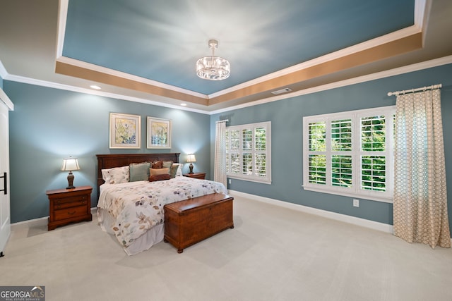 bedroom with a tray ceiling, a chandelier, and light colored carpet