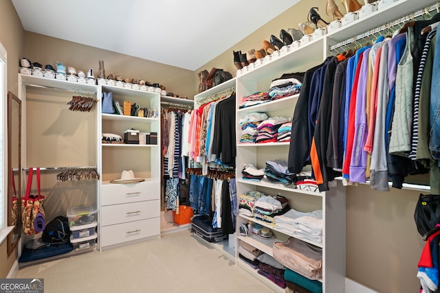 spacious closet featuring light colored carpet