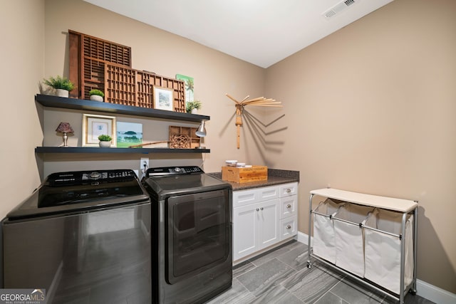 laundry area featuring independent washer and dryer and cabinets