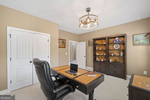 home office featuring light carpet and a chandelier