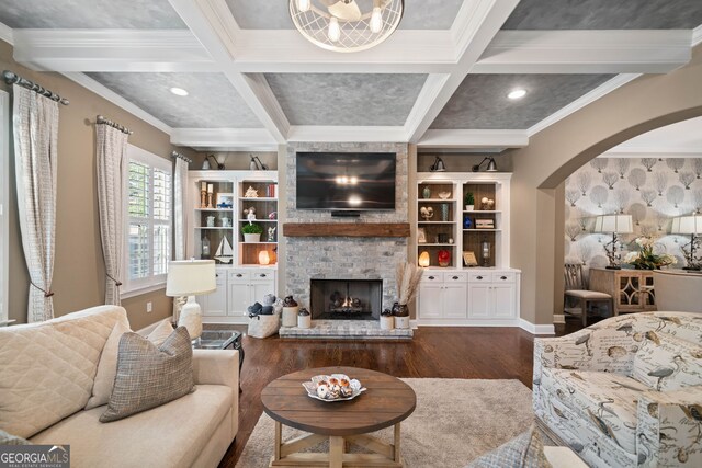 living room featuring crown molding, coffered ceiling, dark hardwood / wood-style flooring, and a fireplace