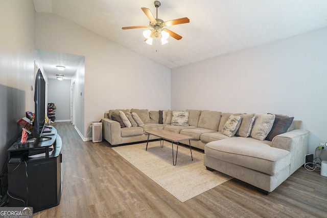 living room featuring ceiling fan, hardwood / wood-style flooring, and lofted ceiling