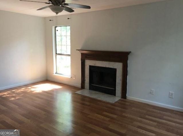 unfurnished living room featuring ceiling fan, a wealth of natural light, and dark hardwood / wood-style floors