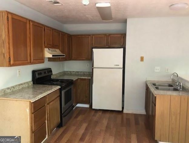 kitchen with sink, black electric range oven, white fridge, and dark hardwood / wood-style floors