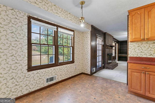 unfurnished dining area featuring a textured ceiling and a fireplace