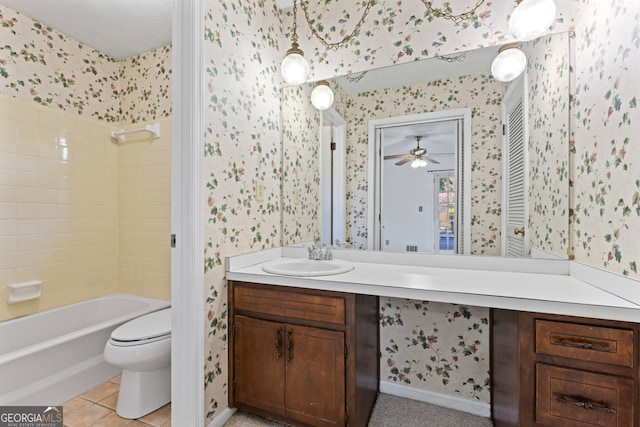 full bathroom featuring tiled shower / bath, vanity, toilet, and ceiling fan