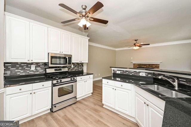 kitchen featuring sink, appliances with stainless steel finishes, white cabinetry, and tasteful backsplash