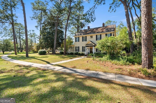 colonial inspired home featuring a front lawn