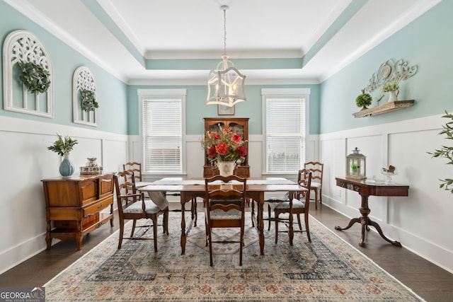 dining area with a raised ceiling and dark hardwood / wood-style floors