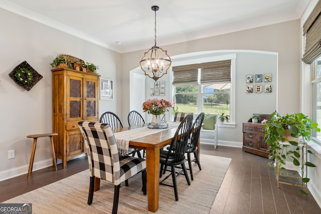 dining area with an inviting chandelier, crown molding, and dark hardwood / wood-style floors