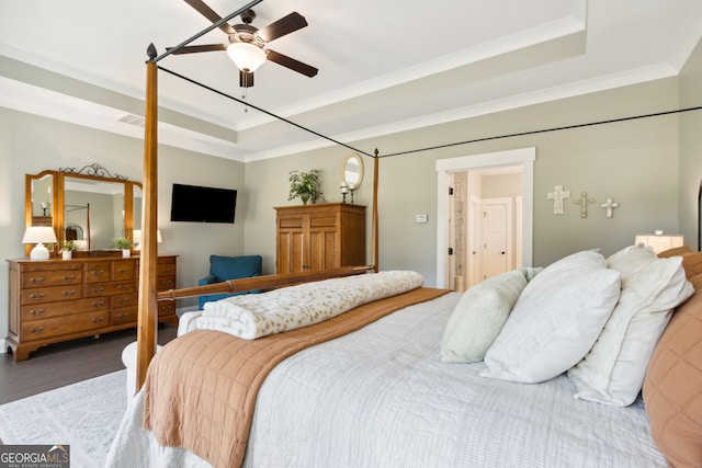 bedroom featuring ornamental molding, hardwood / wood-style floors, a tray ceiling, and ceiling fan