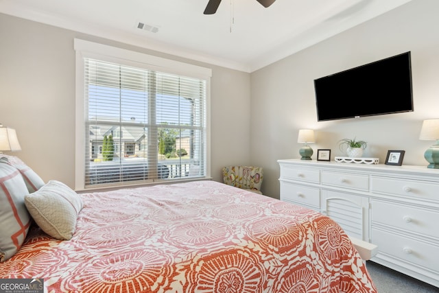 carpeted bedroom with ceiling fan, ornamental molding, and visible vents
