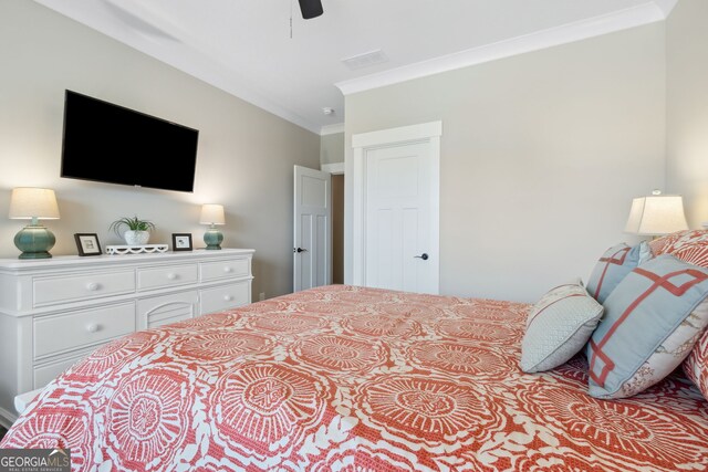 bedroom featuring ceiling fan, ornamental molding, and visible vents
