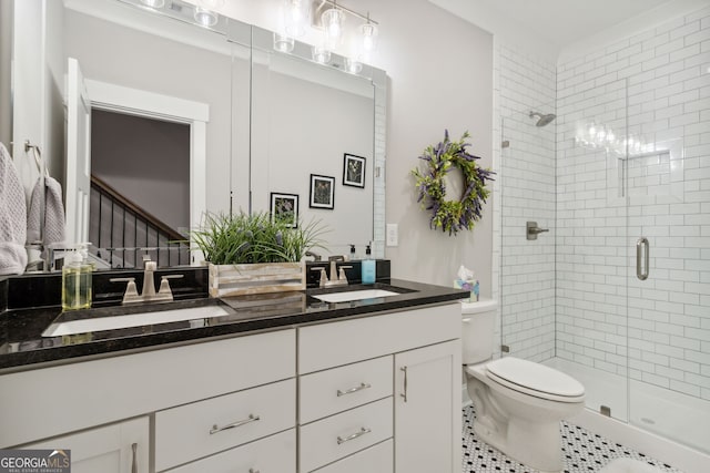 full bathroom with double vanity, a shower stall, toilet, and a sink