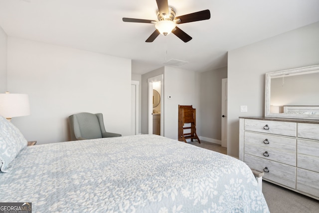 bedroom featuring ceiling fan, ensuite bathroom, and light colored carpet