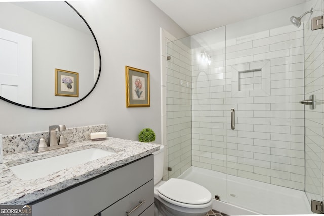 bathroom with toilet, an enclosed shower, and vanity