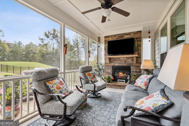 sunroom with an outdoor living space with a fireplace and ceiling fan