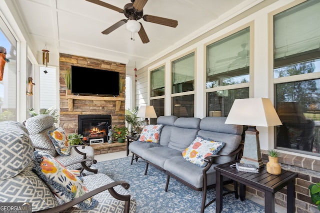 exterior space with ceiling fan and a stone fireplace