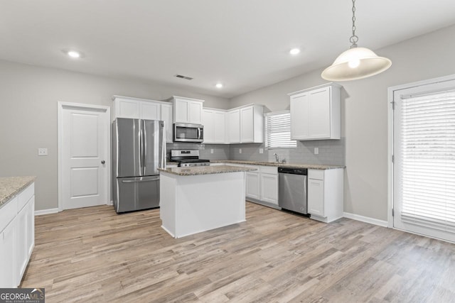 kitchen featuring visible vents, stainless steel appliances, hanging light fixtures, and white cabinetry