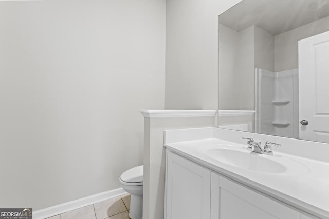 bathroom with baseboards, toilet, tile patterned floors, walk in shower, and vanity