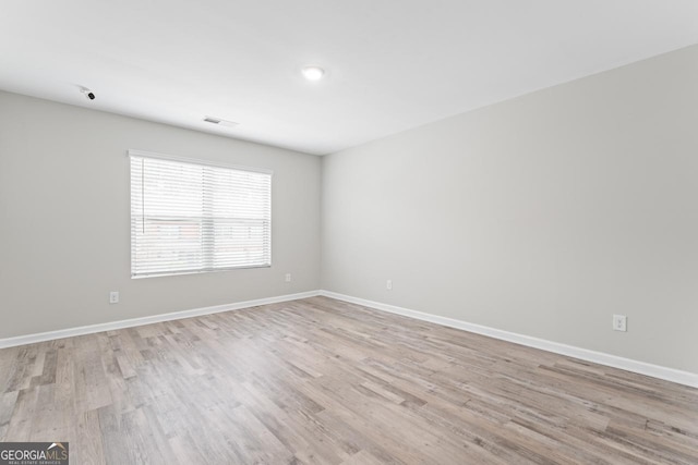 unfurnished room featuring light wood-type flooring and baseboards