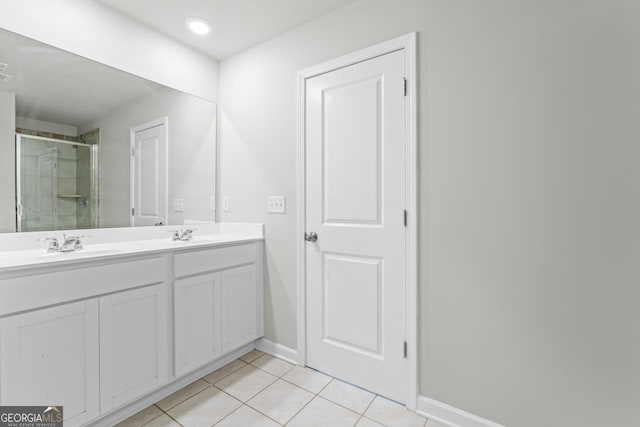 full bathroom featuring double vanity, baseboards, tile patterned flooring, a shower stall, and a sink