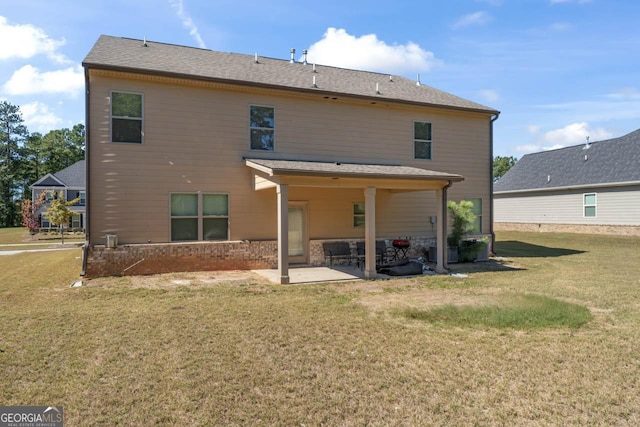 back of house featuring brick siding, a patio, and a lawn