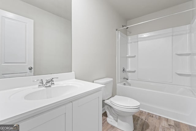 full bathroom featuring wood-type flooring, toilet, shower / bathing tub combination, and vanity