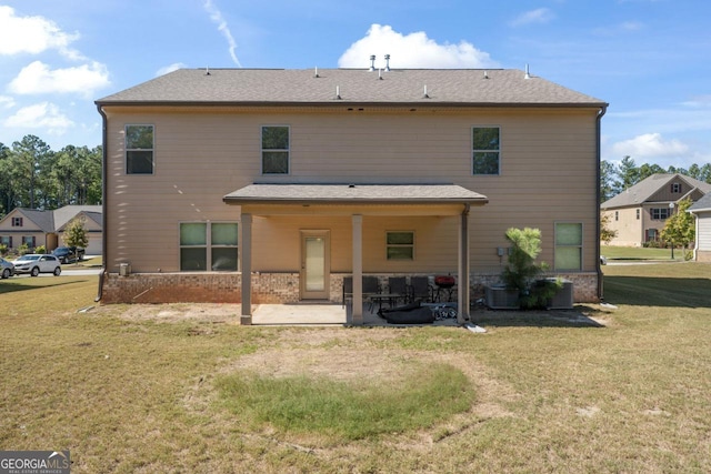 back of house with central air condition unit, a patio area, and a lawn