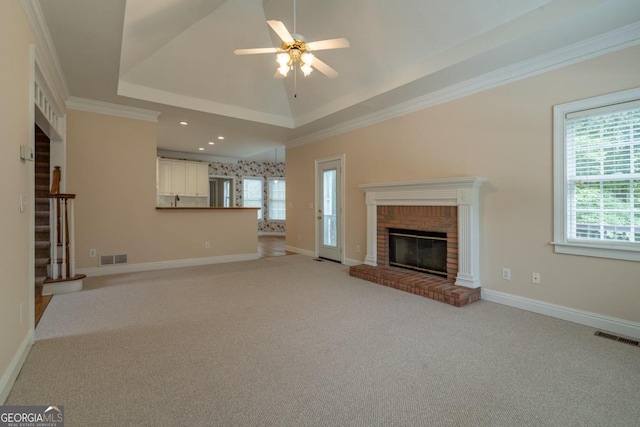 unfurnished living room with ornamental molding, light colored carpet, and plenty of natural light