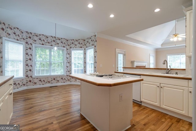 kitchen with sink, a center island, white cabinetry, ceiling fan, and light hardwood / wood-style flooring