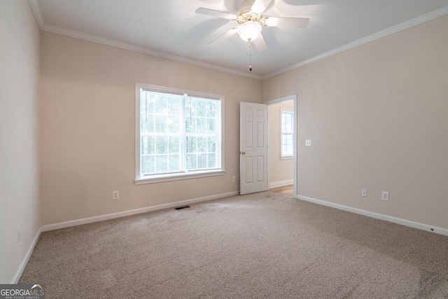 empty room featuring crown molding, light carpet, and ceiling fan