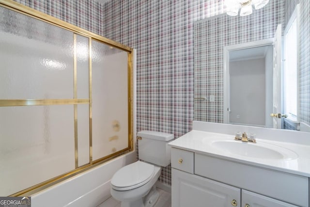 full bathroom with toilet, bath / shower combo with glass door, and vanity