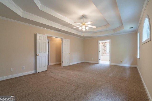 spare room featuring crown molding, ceiling fan, carpet, and a raised ceiling